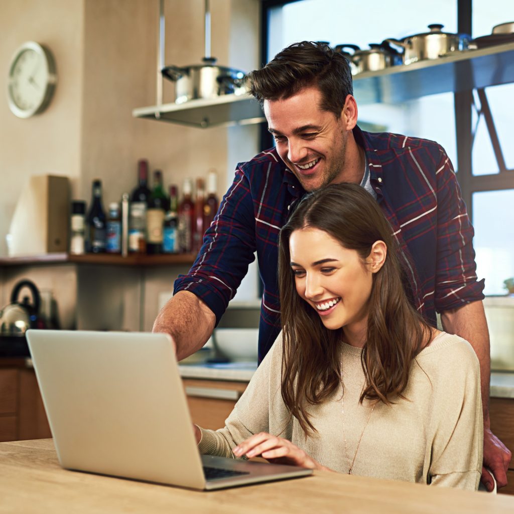 Cropped shot of a young couple using a laptop together at home